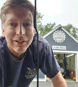 Mechanic in the service bay with a vehicle on the lift